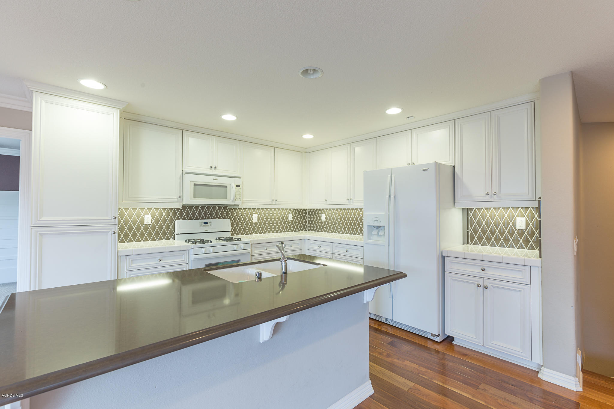 550 Southampton Place Oxnard, CA 93035 - Photo 4 of 12 a view of a kitchen with a sink wooden cabinets and refrigerator