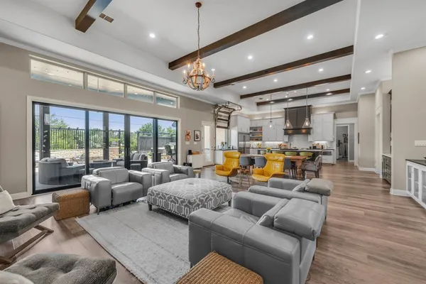 a living room with furniture kitchen area and a large window