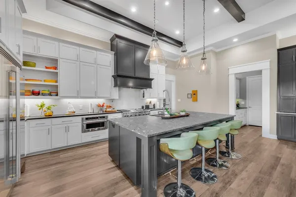 a kitchen with stainless steel appliances granite countertop a table chairs stove and wooden floor