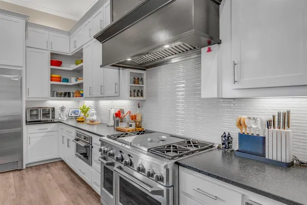 a kitchen with stainless steel appliances granite countertop a stove and a refrigerator