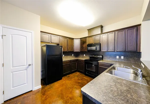 a kitchen with stainless steel appliances granite countertop a refrigerator stove and sink