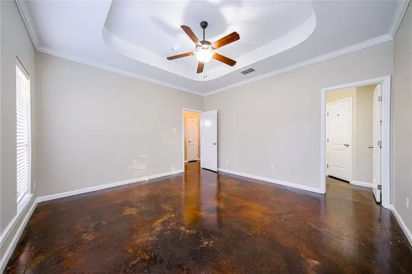 an empty room with closet and a ceiling fan