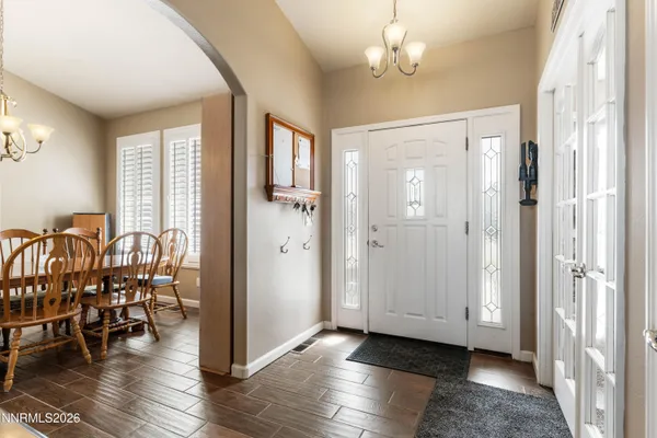 a view of a dining room with furniture a chandelier and wooden floor