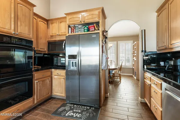 a kitchen with stainless steel appliances granite countertop a refrigerator a stove and a sink
