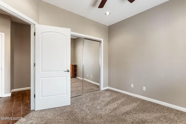 an empty room with closet and a chandelier fan