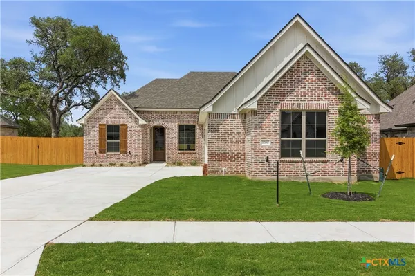 a front view of a house with a garden and yard