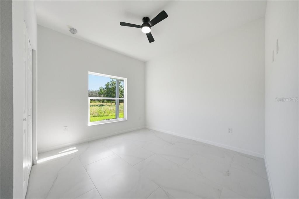 3174 North Sedgewick Road Avon Park, FL 33825 - Photo 11 of 12 an empty room with a window and a ceiling fan