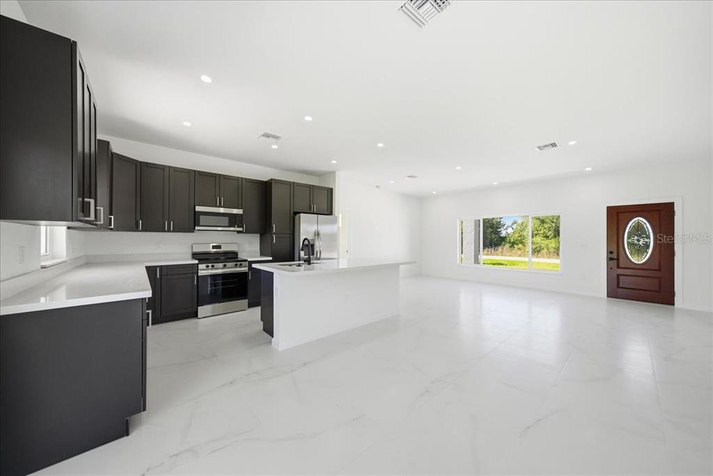 3174 North Sedgewick Road Avon Park, FL 33825 - Photo 7 of 12 a view of kitchen with stainless steel appliances a refrigerator and a stove top oven