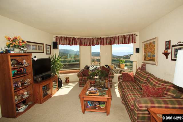 1991 Saddleback Road Reno, NV 89521 - Photo 6 of 13 a living room with furniture a flat screen tv and a floor to ceiling window
