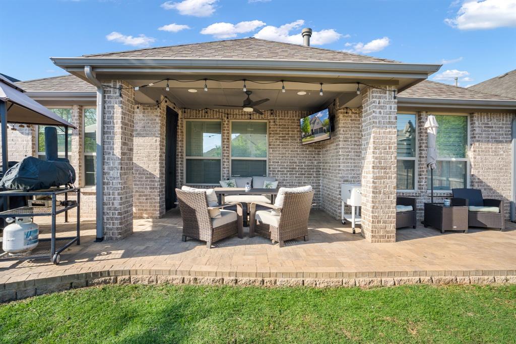 1501 Snowdrop Drive Prosper, TX 75078 - Photo 26 of 27 a view of a patio with table and chairs potted plants and a bench