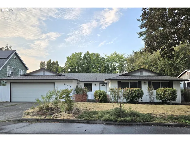 a front view of a house with a yard and potted plants