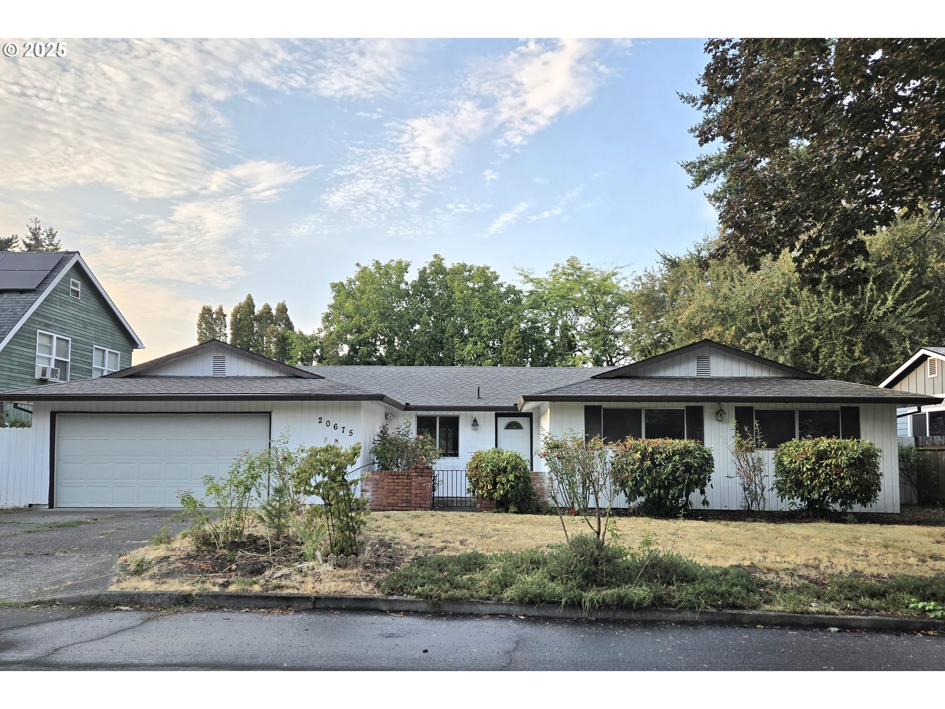 a front view of a house with a yard and potted plants