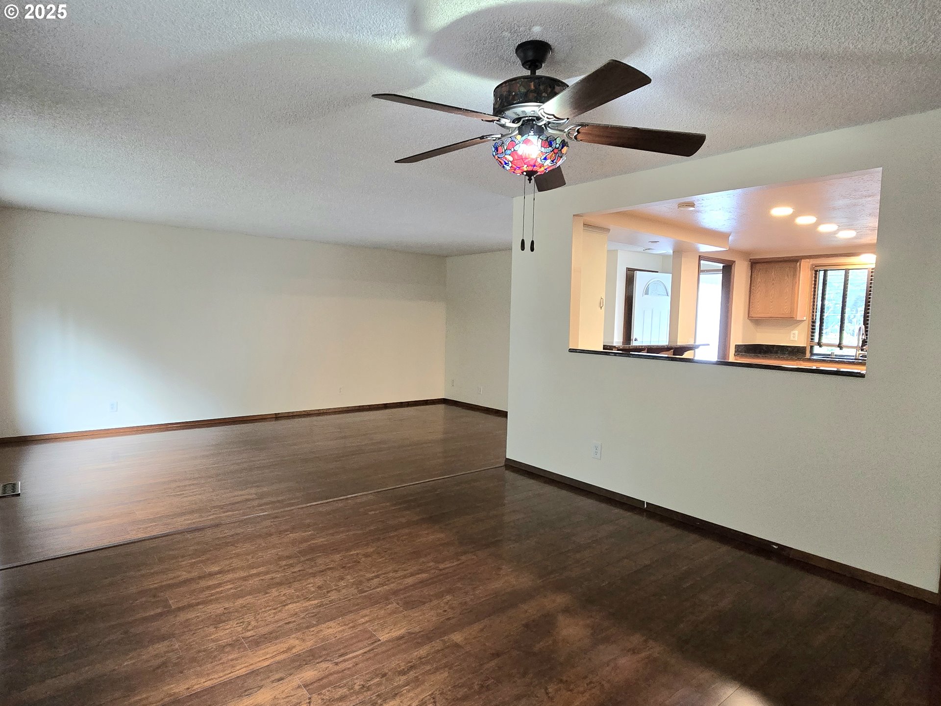 20675 Southwest Rosa Drive Beaverton, OR 97078 - Photo 12 of 40 an empty room with wooden floor chandelier fan and windows