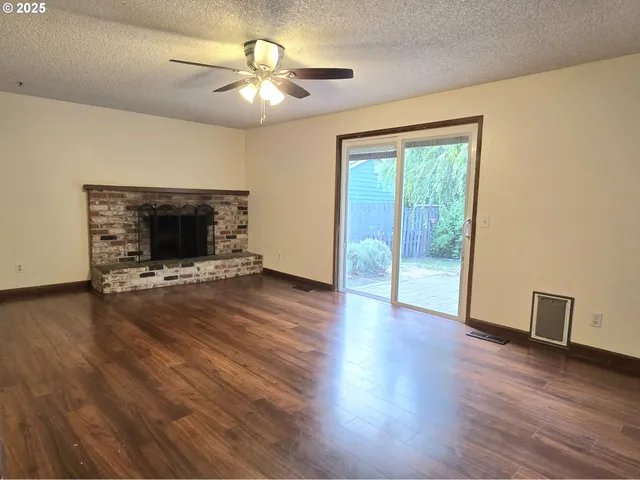 a living room with wooden floor and a fireplace