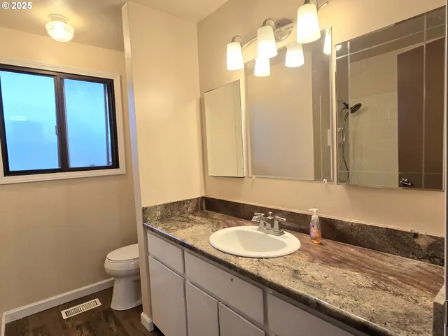 a bathroom with a granite countertop sink and a mirror