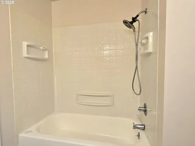 a bathroom with a bath tub with a shower
