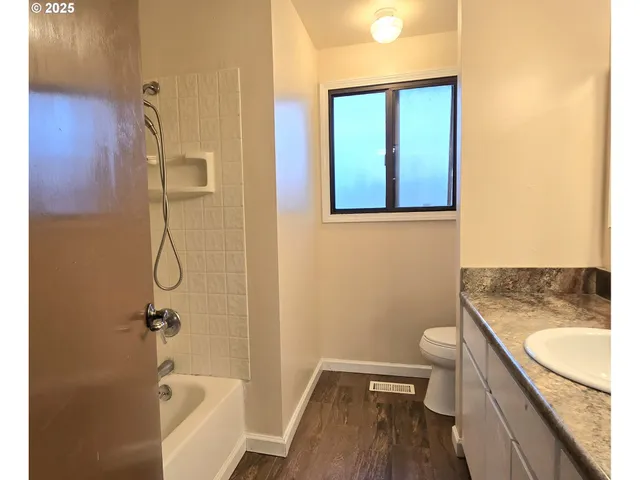 a bathroom with a granite countertop toilet a sink and bathtub