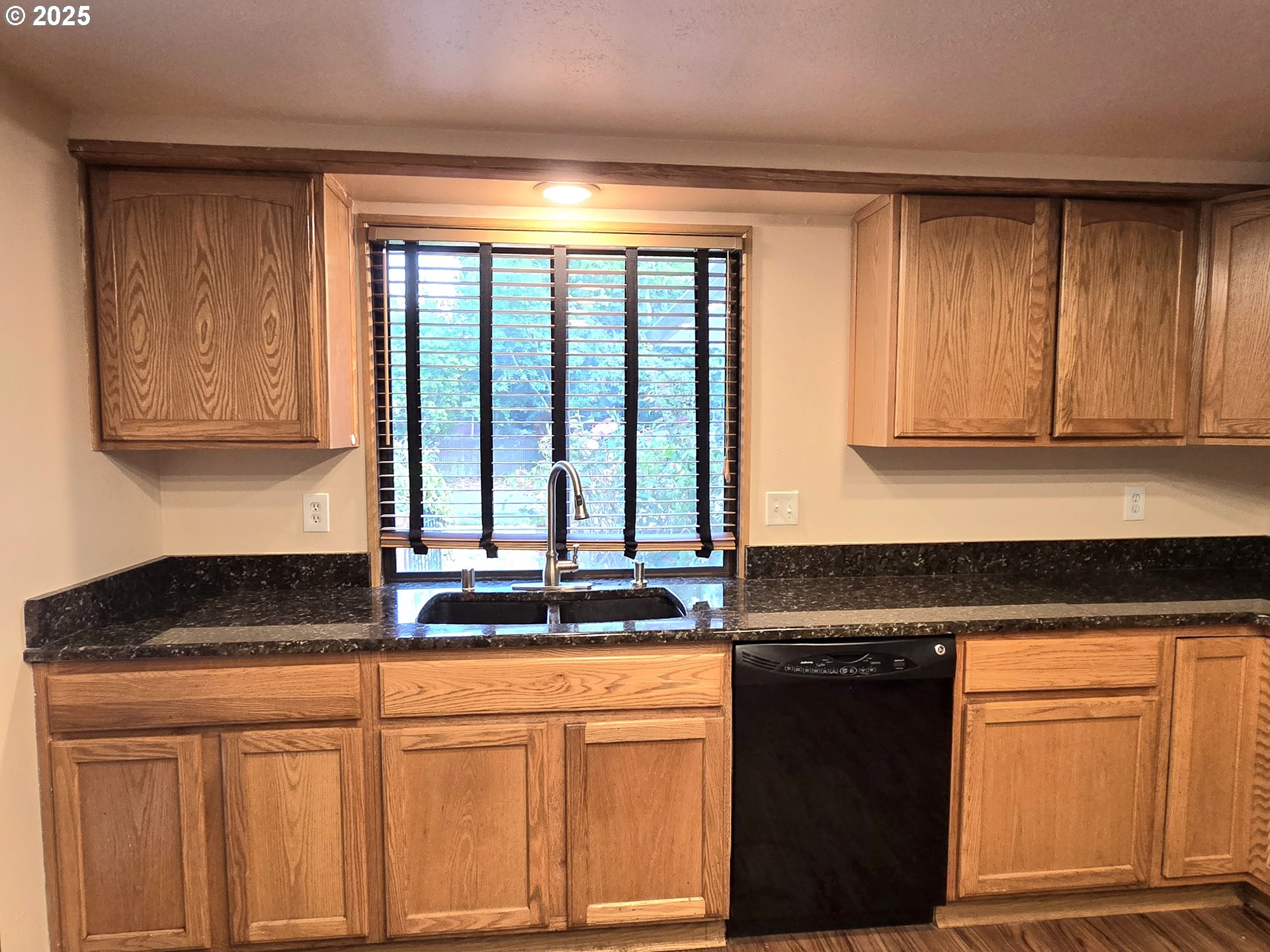 20675 Southwest Rosa Drive Beaverton, OR 97078 - Photo 9 of 40 a kitchen with granite countertop white cabinets and black appliances