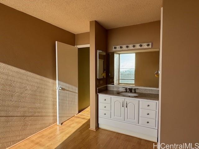 98-707 Iho Place, Unit 1004 Aiea, HI 96701 - Photo 12 of 20 a bathroom with a granite countertop sink and a mirror