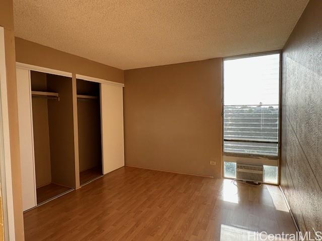 98-707 Iho Place, Unit 1004 Aiea, HI 96701 - Photo 9 of 20 an empty room with wooden floor and windows with curtains