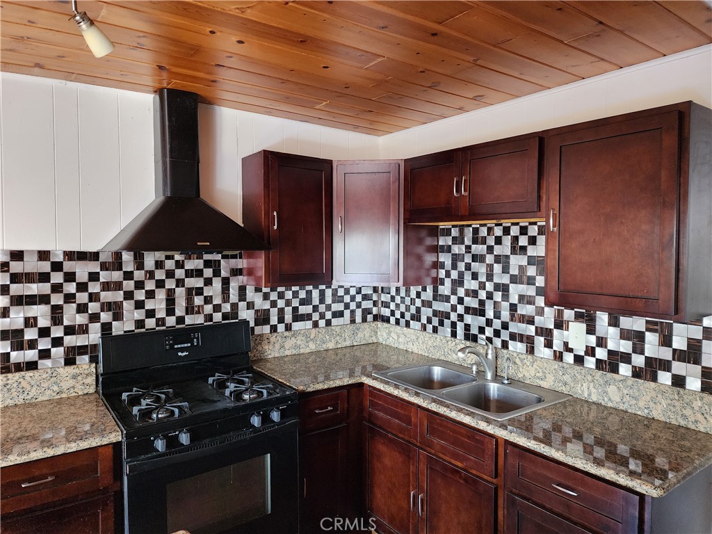 21657 Vista Road Cedarpines Park, CA 92322 - Photo 15 of 39 a kitchen with granite countertop a stove and cabinets