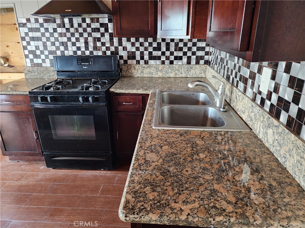 21657 Vista Road Cedarpines Park, CA 92322 - Photo 16 of 39 a kitchen with granite countertop a stove a sink and a microwave