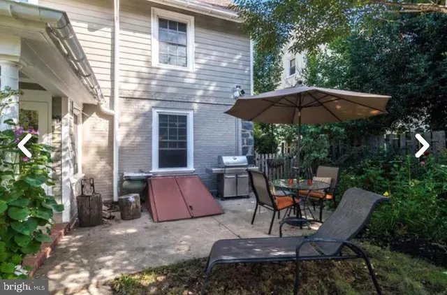 a patio with a table and chairs under an umbrella
