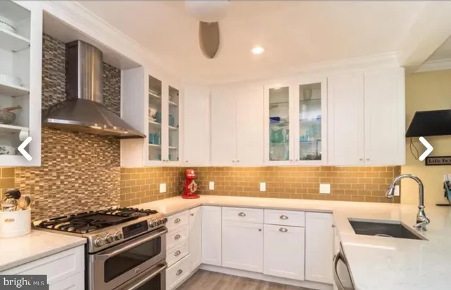 a kitchen with granite countertop a stove sink and cabinets