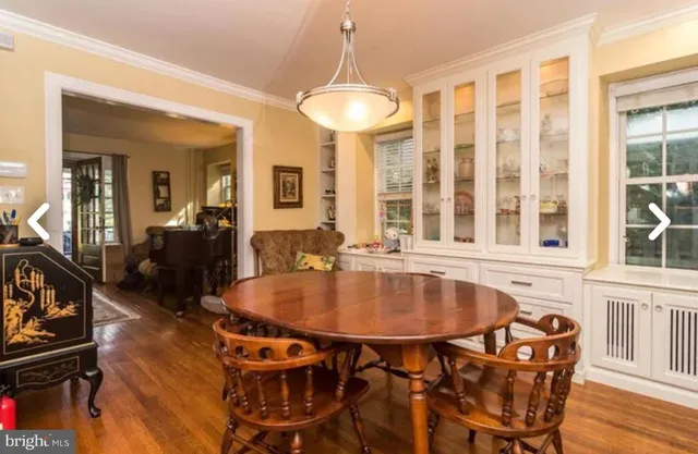 a dining room with furniture a chandelier and wooden floor