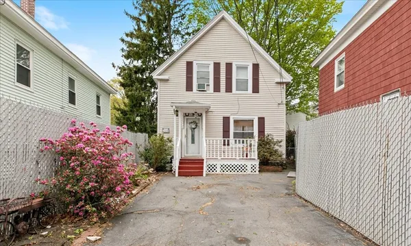 a view of a house with a yard and potted plants