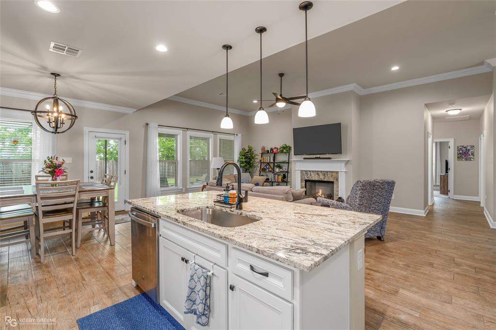 122 Brimestone Loop Benton, LA 71006 - Photo 8 of 33 a open kitchen with stainless steel appliances granite countertop a stove a oven a kitchen island a dining table and chairs with wooden floor