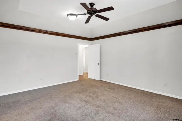 a view of a room with a ceiling fan and window