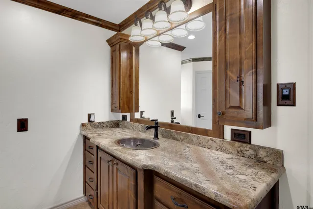 a bathroom with a granite countertop sink and a mirror