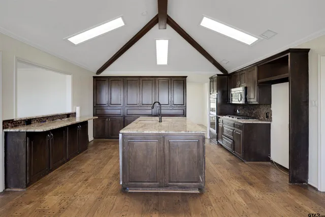 a kitchen that has a sink in it and wooden floors