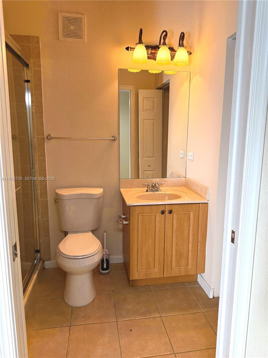 120 Cat Rock Lane Jupiter, FL 33458 - Photo 26 of 28 a bathroom with a toilet a sink and a mirror