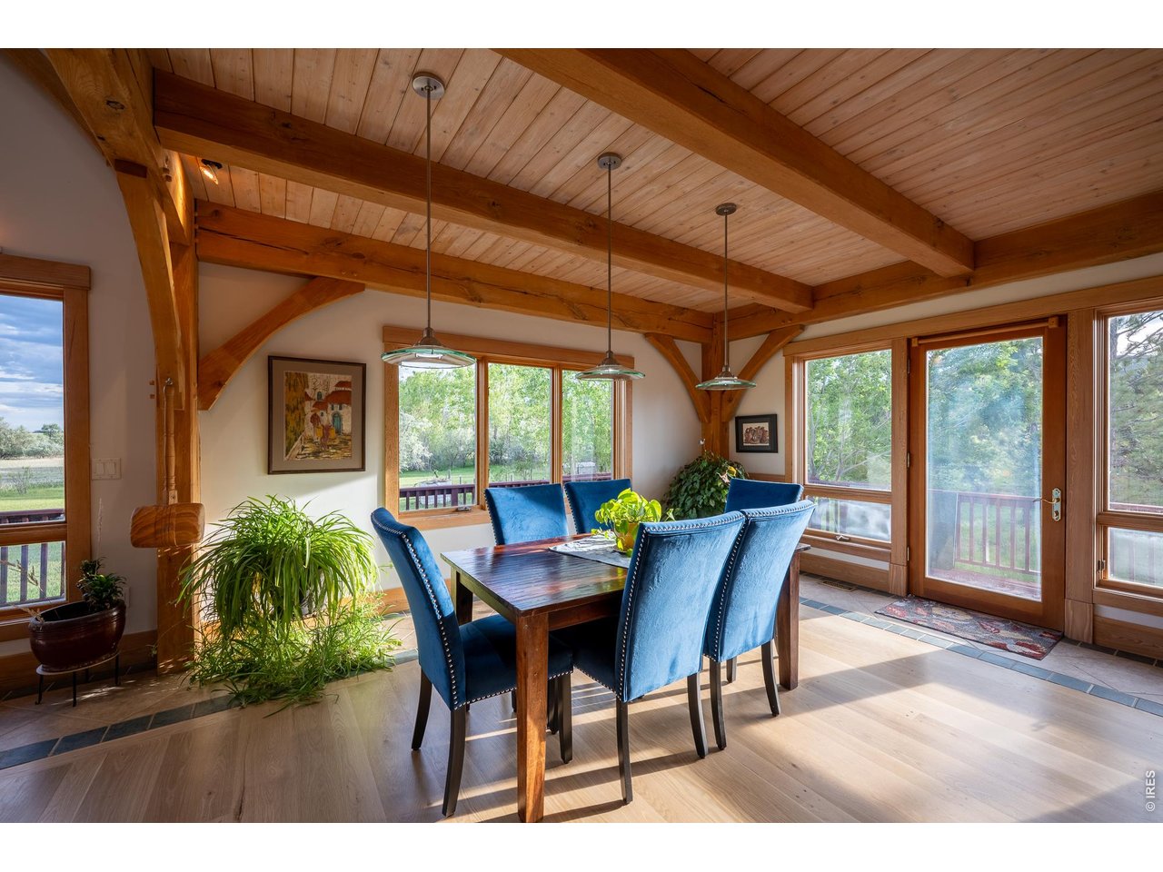 4099 Michaud Lane Fort Collins, CO 80521 - Photo 32 of 50 The dining room is warm and inviting, surrounded by windows and doors that open to the wraparound deck, creating the perfect setting for gathering with family and hosting guests.