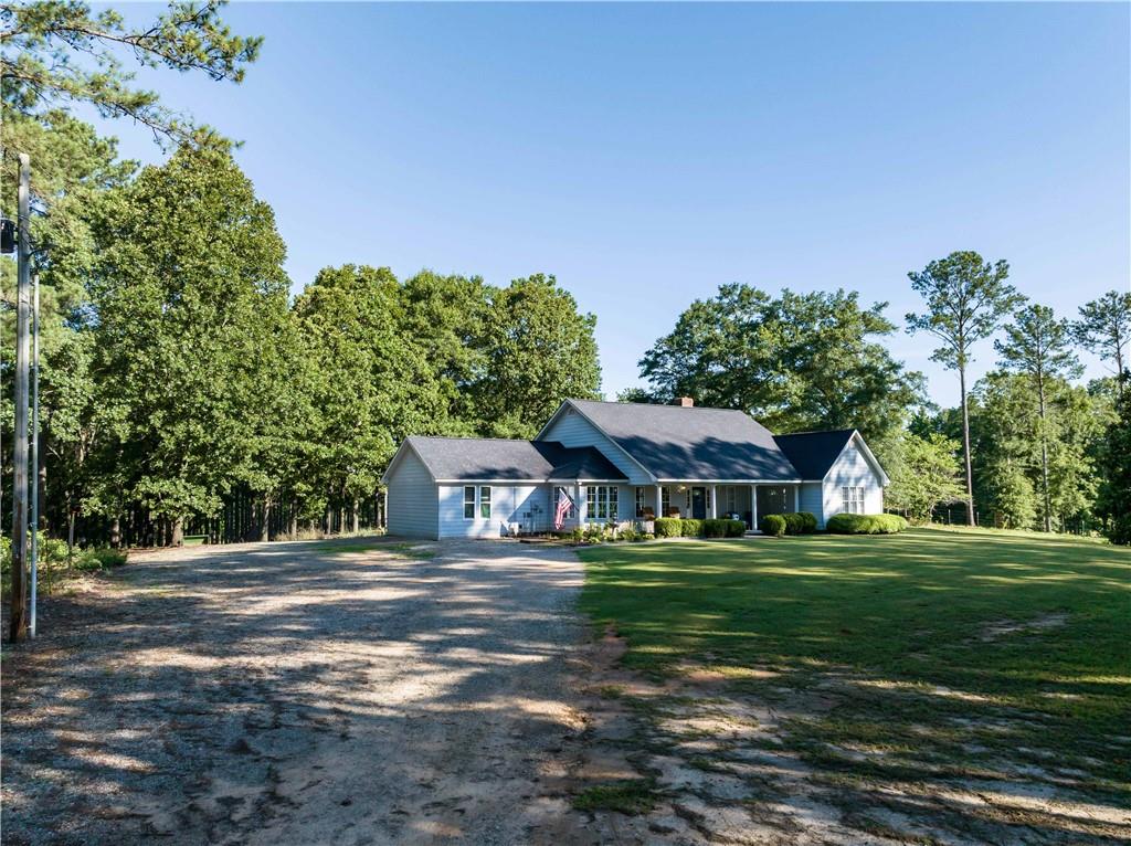 62 McCarthy Road Opelika, AL 36804 - Photo 66 of 74 Light blue siding residence featuring a dark shingle roof and a covered front porch