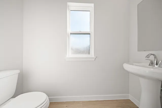 a bathroom with a toilet sink and mirror