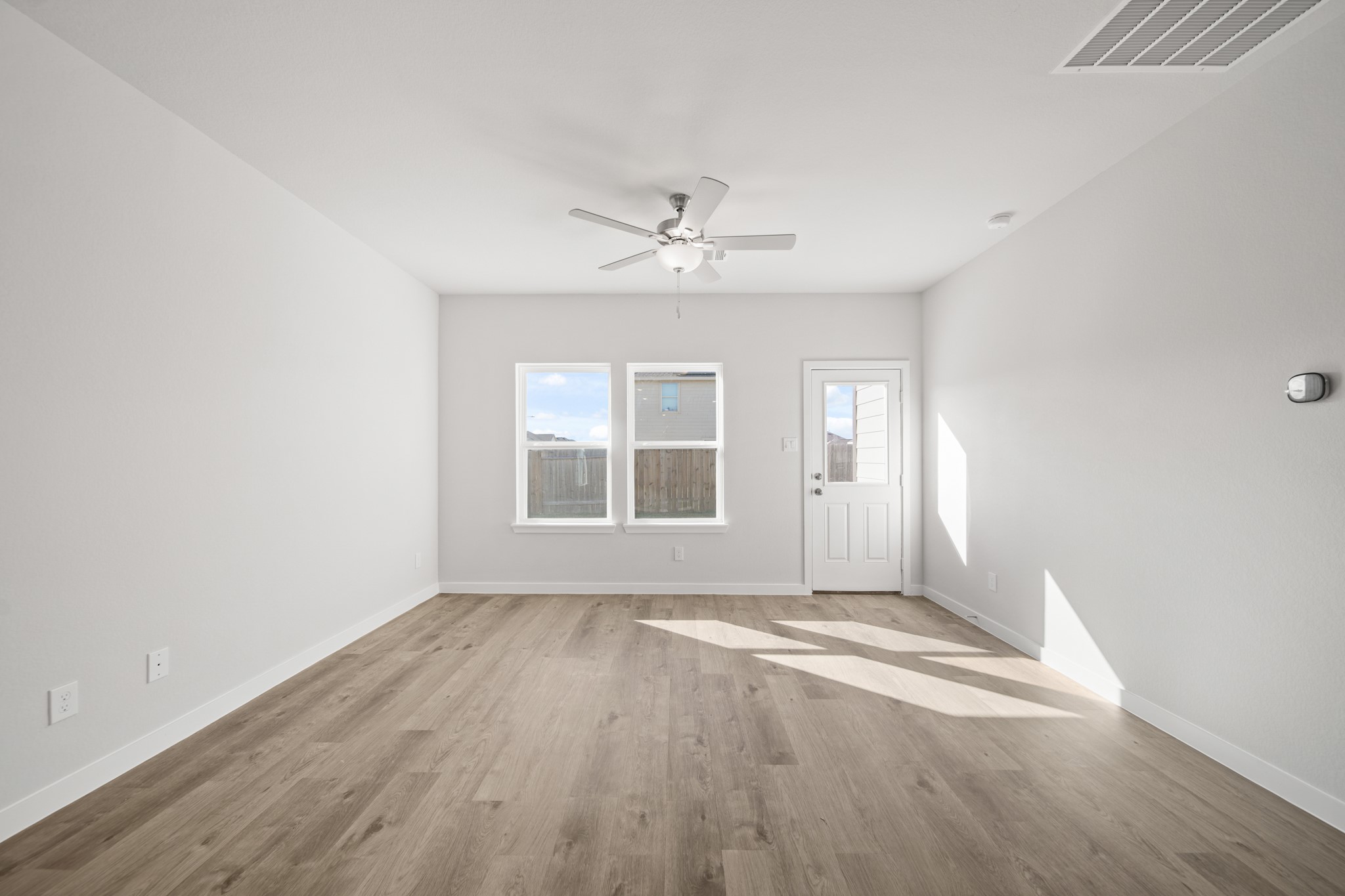305 Bennett Street Angleton, TX 77515 - Photo 8 of 27 an empty room with wooden floor ceiling fan and windows