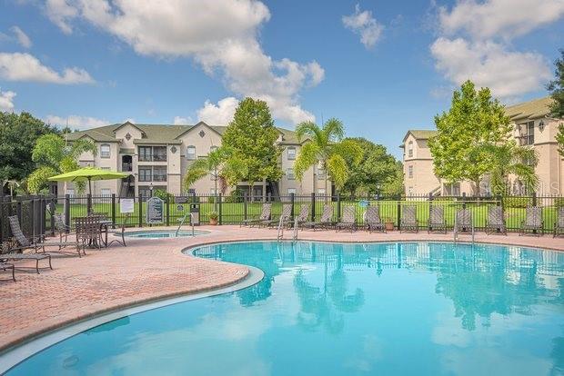 9515 Grovedale Circle, Unit 101 Riverview, FL 33578 - Photo 21 of 22 a view of a swimming pool with an outdoor space and seating area