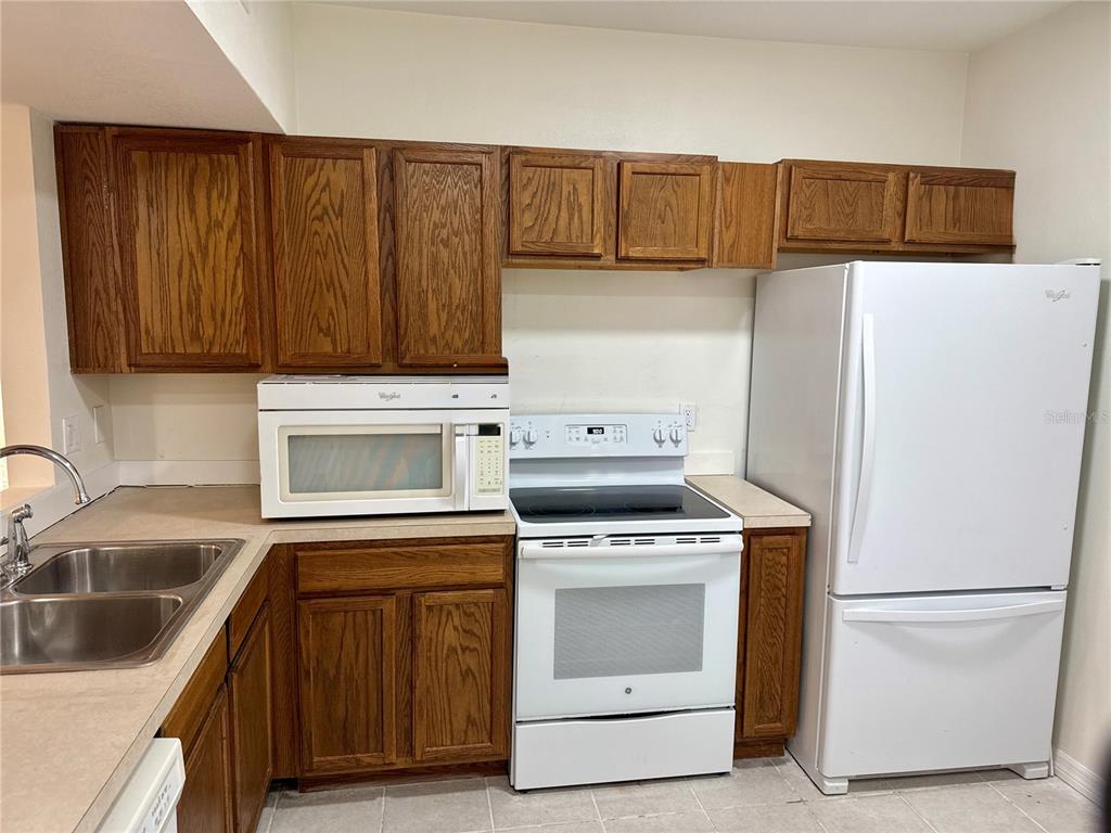 9515 Grovedale Circle, Unit 101 Riverview, FL 33578 - Photo 6 of 22 a kitchen with a refrigerator sink and cabinets