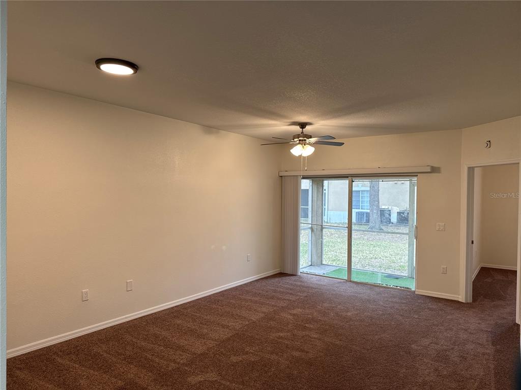 9515 Grovedale Circle, Unit 101 Riverview, FL 33578 - Photo 7 of 22 an empty room with chandelier fan and windows