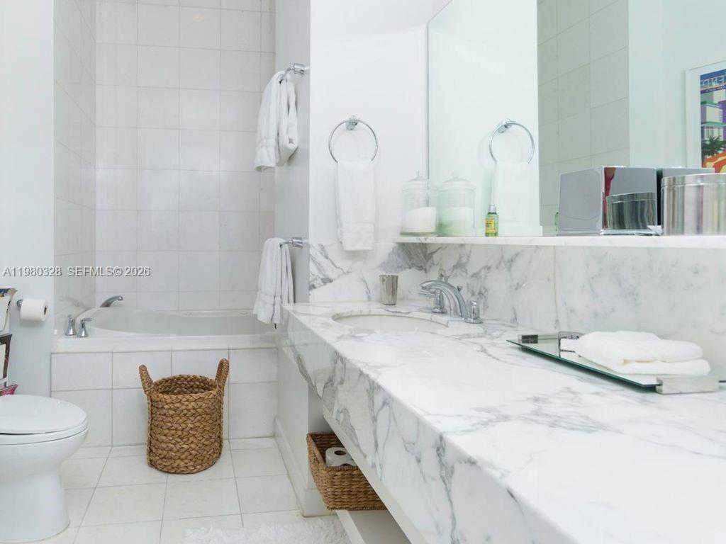2001 Meridian Avenue, Unit 414 Miami Beach, FL 33139 - Photo 13 of 22 a bathroom with a granite countertop sink and a mirror