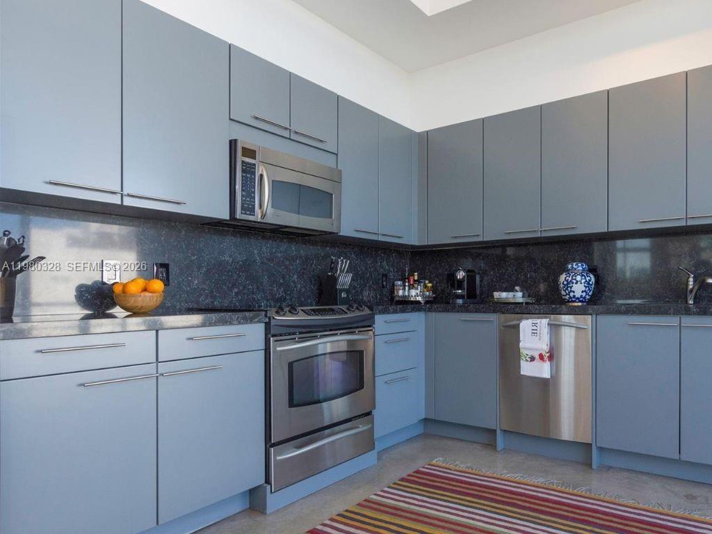 2001 Meridian Avenue, Unit 414 Miami Beach, FL 33139 - Photo 8 of 22 a kitchen with stainless steel appliances granite countertop a sink and a stove