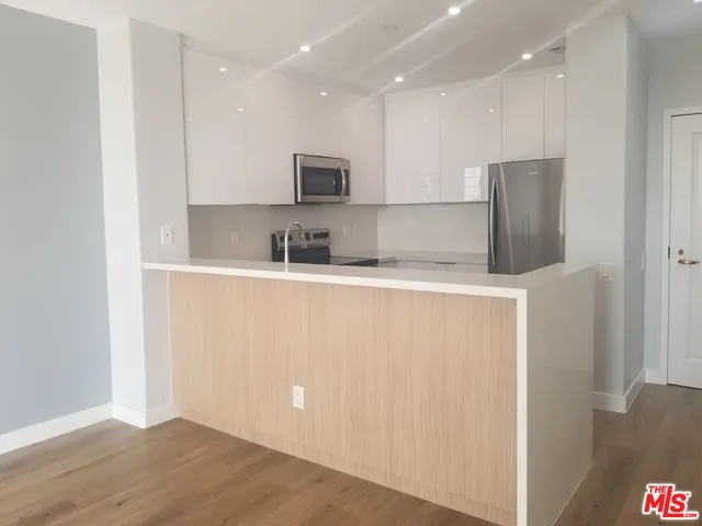 a view of kitchen with stainless steel appliances granite countertop refrigerator sink and microwave