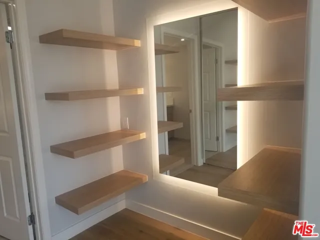 a view of walk in closet with empty racks