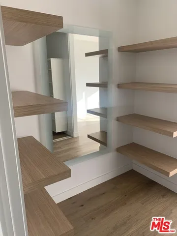 a view of walk in closet with empty racks