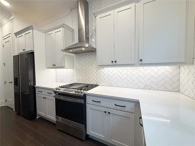 a kitchen with white cabinets and black appliances