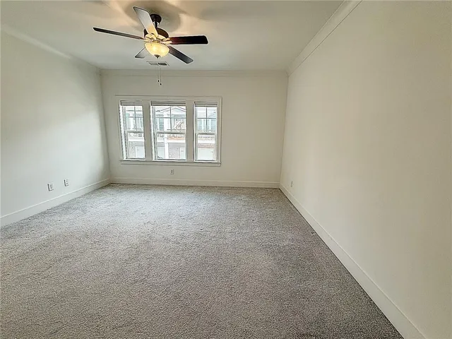 an empty room with a window and a fan