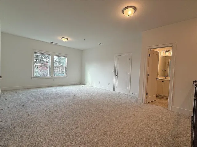 an empty room with windows and closet area